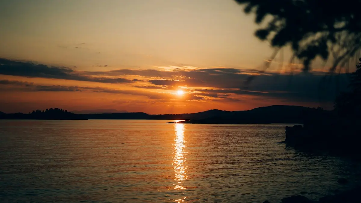 A vibrant sunset reflecting on the calm coastal waters of Desolation Sound during a British Columbia yacht charter
