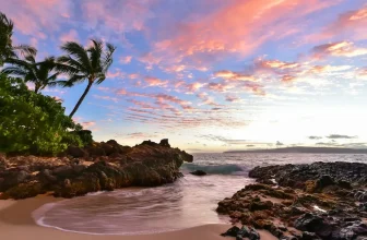 Intimate crescent of golden sand and black lava rock at Secret Beach in South Maui, a popular anchorage for a Maui yacht charter
