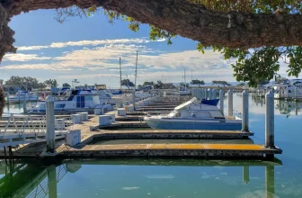 Empty marina berths with docked boats in the distance, symbolizing phantom yacht scams and fraudulent charter bookings.